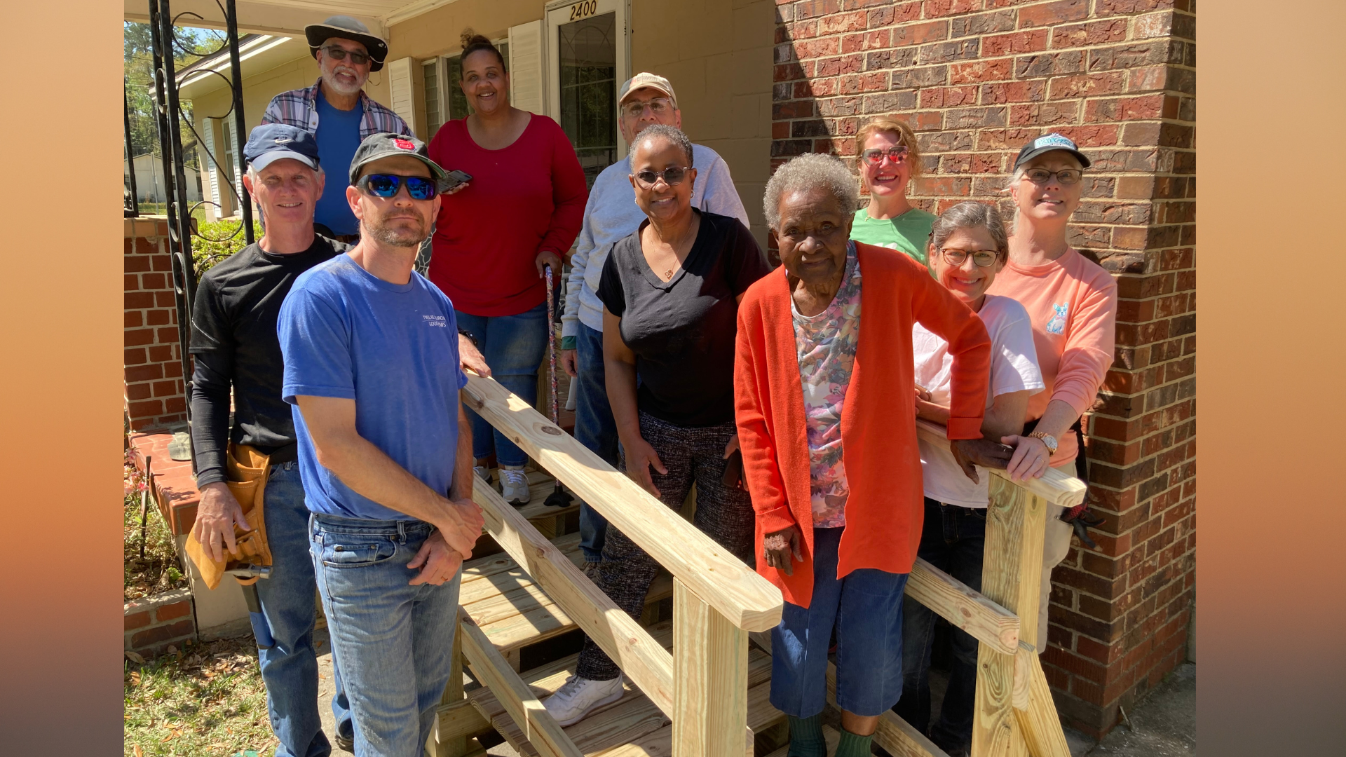 Photo of work crew with a 96 year old Tallahassee resident on the new accessibility ramp just built in front of her house